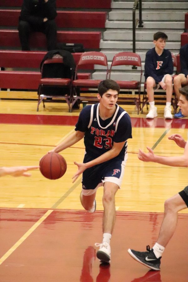 John Shannon takes the ball up the court. Shannon led Foran with 22 of their 61 points. Photo courtesy of Corina Massey. 
