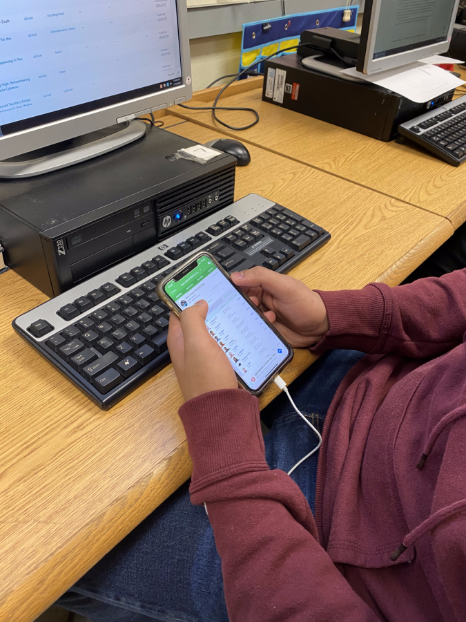 Junior, Juanito Briones, looking at his fantasy team on his phone. 