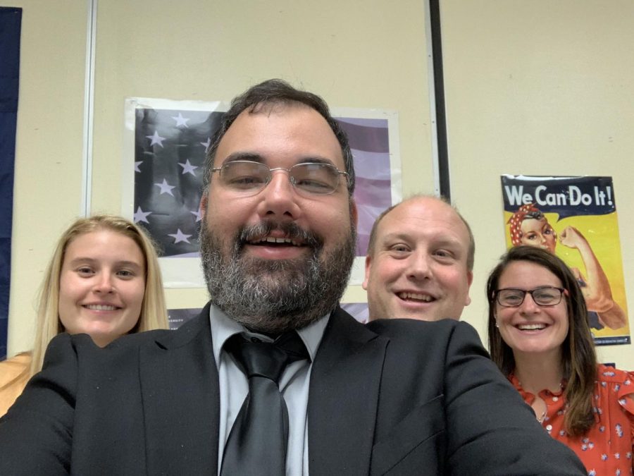 History teacher Frank Tupka takes a picture with fellow staff members before open house night. 