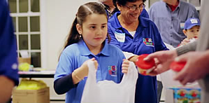 Giving Back at a Young Age: A young volunteer helps fill food bags. 
Photo courtesy of: Food 2 Kids Website