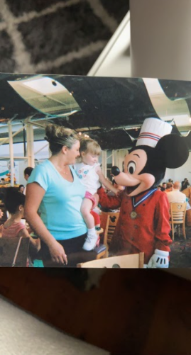 Senior Emily McNulty standing next to Mickey Mouse in her mom’s arms in 2005.                                                      Photo Courtesy: Emily McNulty. 