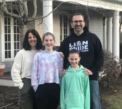 The Berkowitz Family: Berkowitz smiles in front of his home with his wife and two daughters. Photo courtesy Mr. Berkowitz.