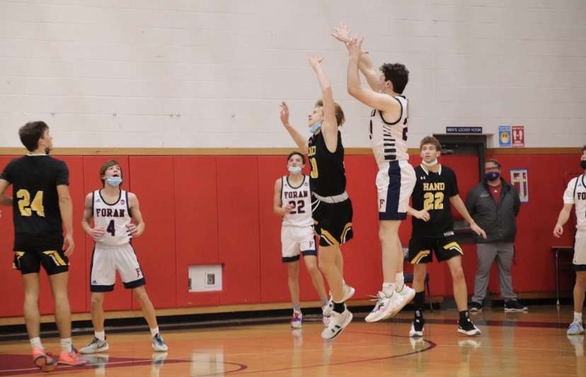Inspiration On The Basketball Court: Foran Basketball player Joe Gaetano shoots a 3 against Hand settling the score against Hand in the Lions Den.