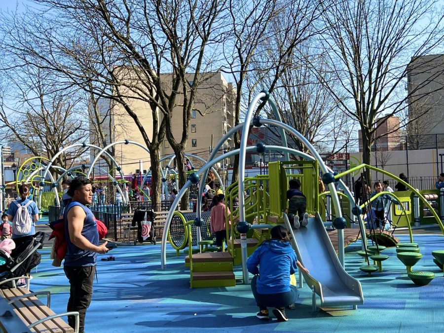 The Playground is the Place to Be: On a clear day, parents take their children to play at the playground. 