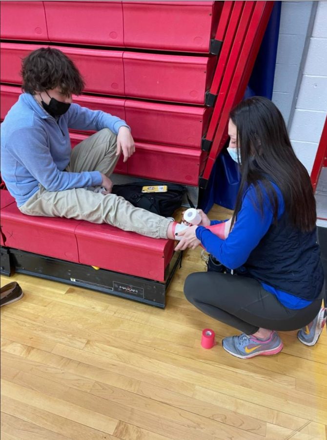 Zuckerman in Action: Zuckerman wraps an athletes ankle before a game.