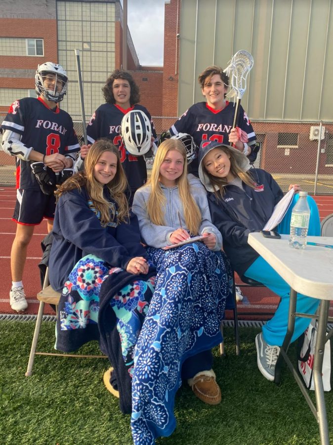 Foran Boys Lacrosse Managers in Action: Reese Jasminski, Sam Lavallee, and Riley Grunow doing stats at the boys game. Photo courtesy: Marina Giammattei, April 11, 2022. 