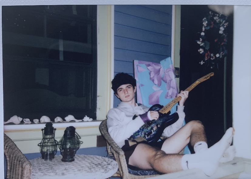 Guitar on the beach:: Leighton Whaley playing guitar on his porch in Milford, CT. early in the morning, May 8, 2022. 