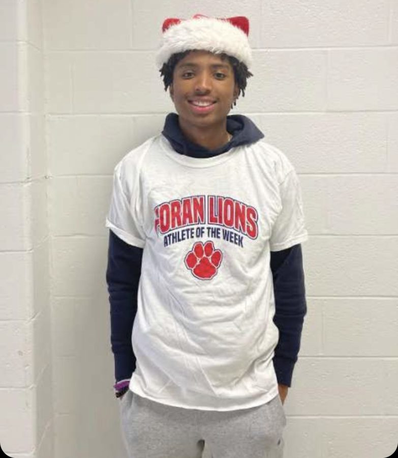 Triumph on the Track: Senior Isaiah Moore in athlete of the week shirt, December 12, 2022. 
