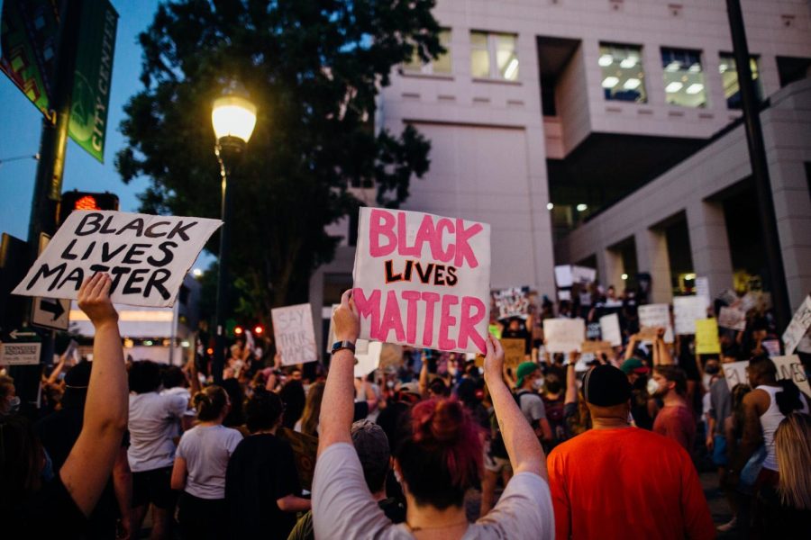Taking to the Streets: Protestors peacefully gather around the center of an American city, holding signs showing their support for the Black Lives Matter movement. Date unknown from Pexels.