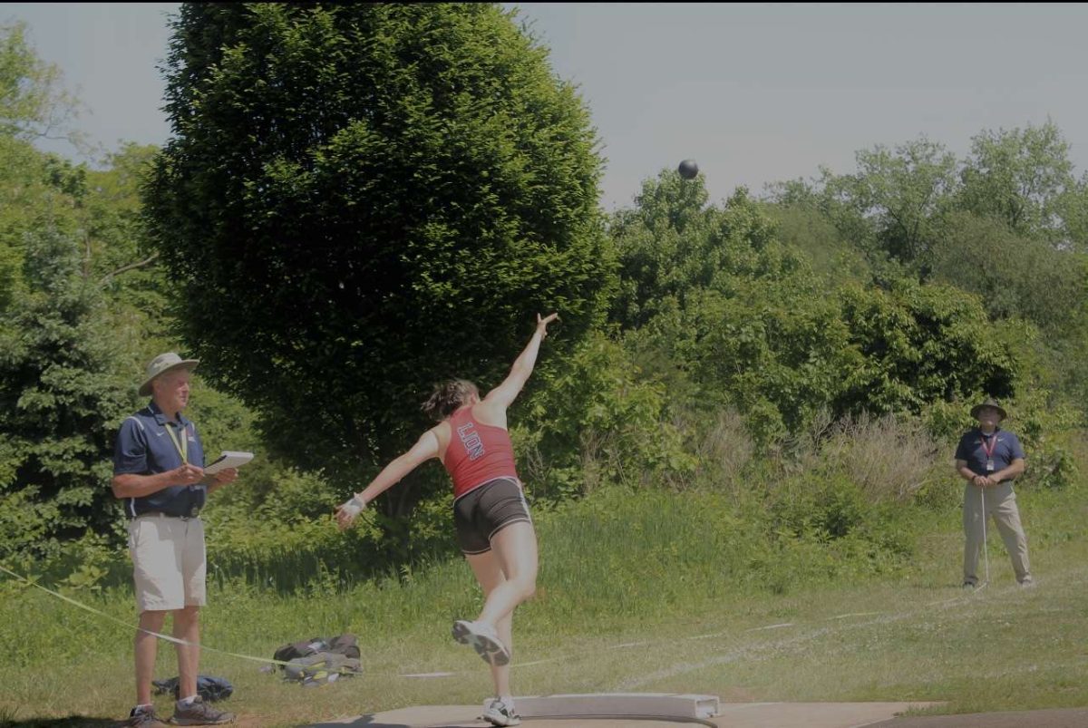 Monster throw: Kelly Aspras, in the middle of throwing shot put at away track meet. 