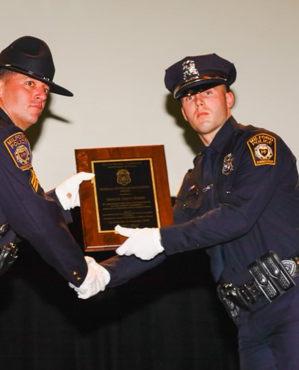 Officially+an+Officer%3A+Brett+Huber+receives+a+plaque+from+Sergeant+Matthew+Mello%2C+December+21%2C+2023.+