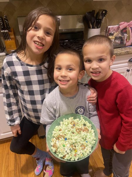 Babysitting Time: Grace, Cappie, and Max making grinch popcorn with their babysitter. December 20, 2023. 