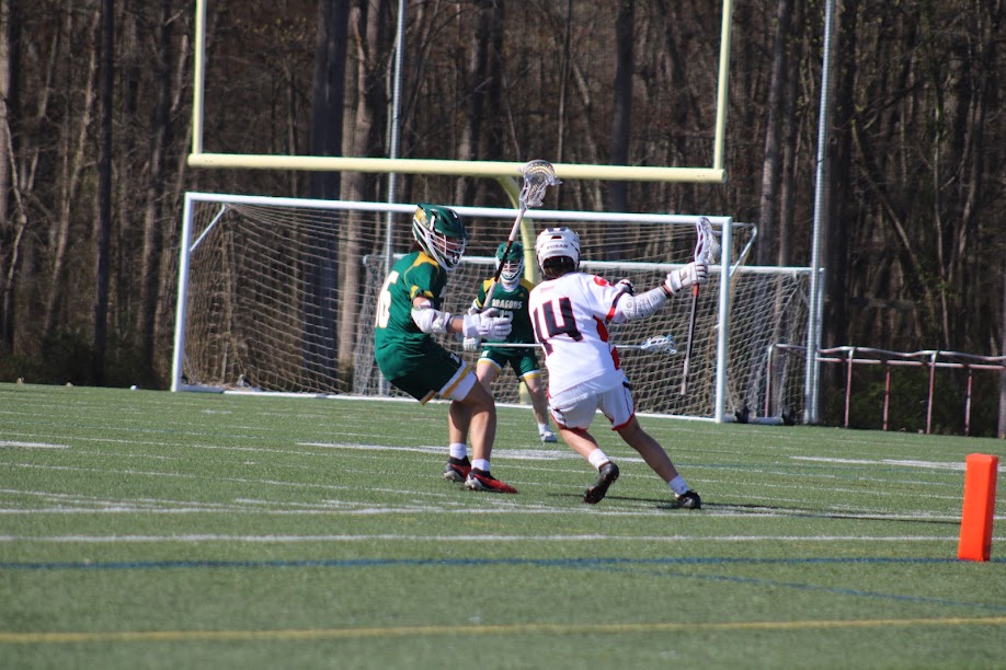 Riley Young #14 trying to get closer to the goal with a Hamden player defending him. 