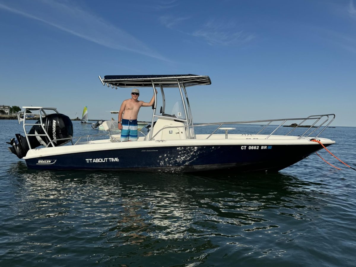 Boston Whaler 230 Dauntless: The dark blue vessel sits on a mooring as the captain poses for a picture in the summer sunshine. July 2, 2024. Photo courtesy: Eric Kerzner