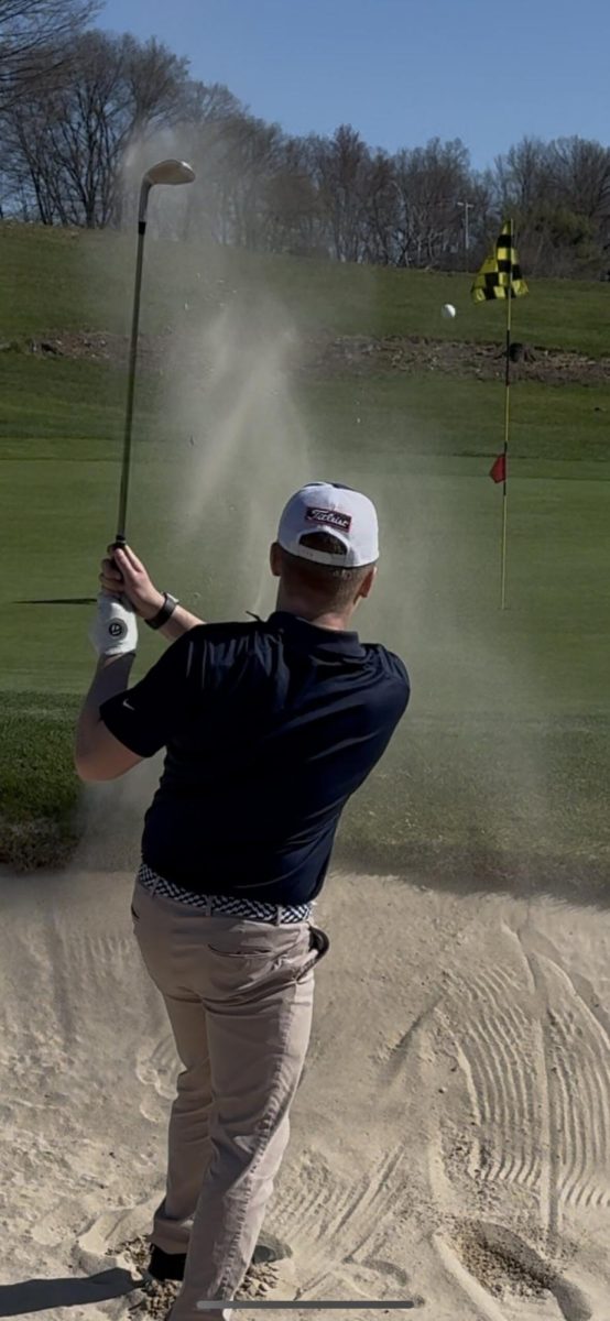 Chip & Lift: Golfer chipping out of the sand trap with a 56-degree sand wedge, approaching the green. April 17, 2025. Photo Courtesy: Matt Stas.