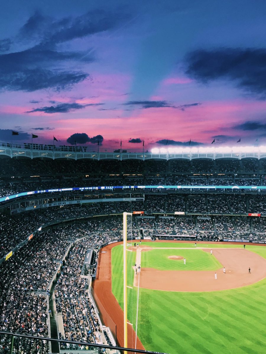 Sunset Night: The sun sets behind Yankee Stadium, painting the skyline during a night game, August 16, 2019. Photo Courtesy: Noah Champagne